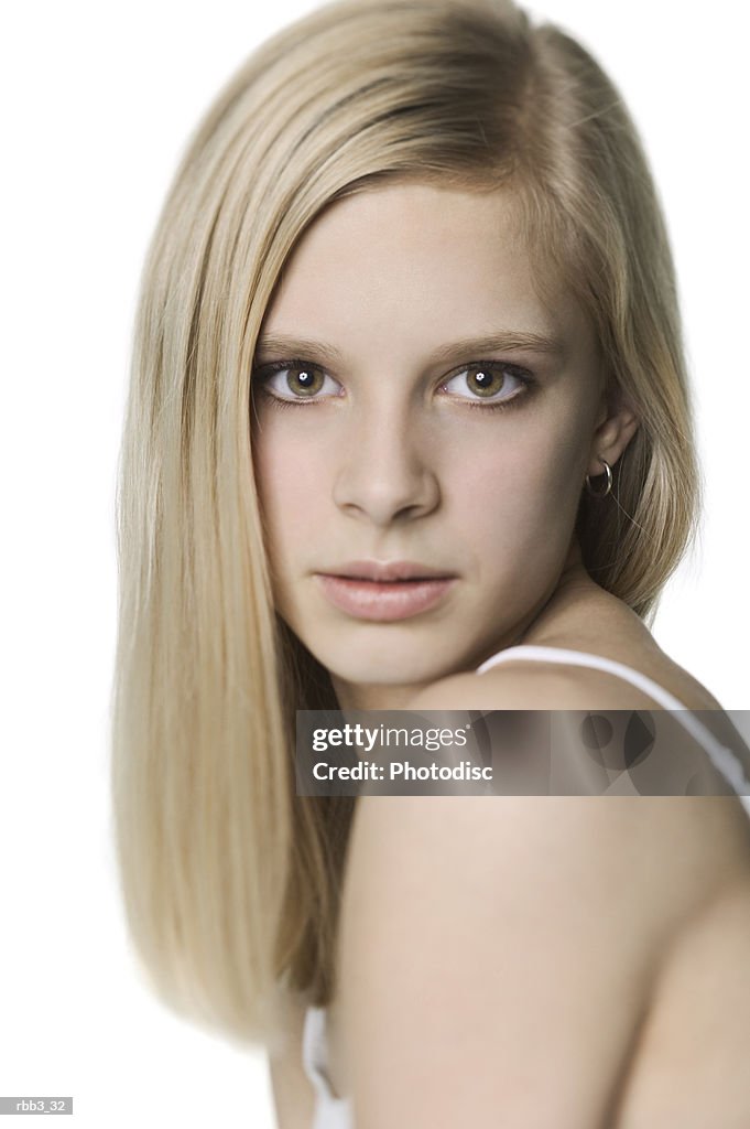 Close up shot of a young blonde woman in a white tank top as she turns