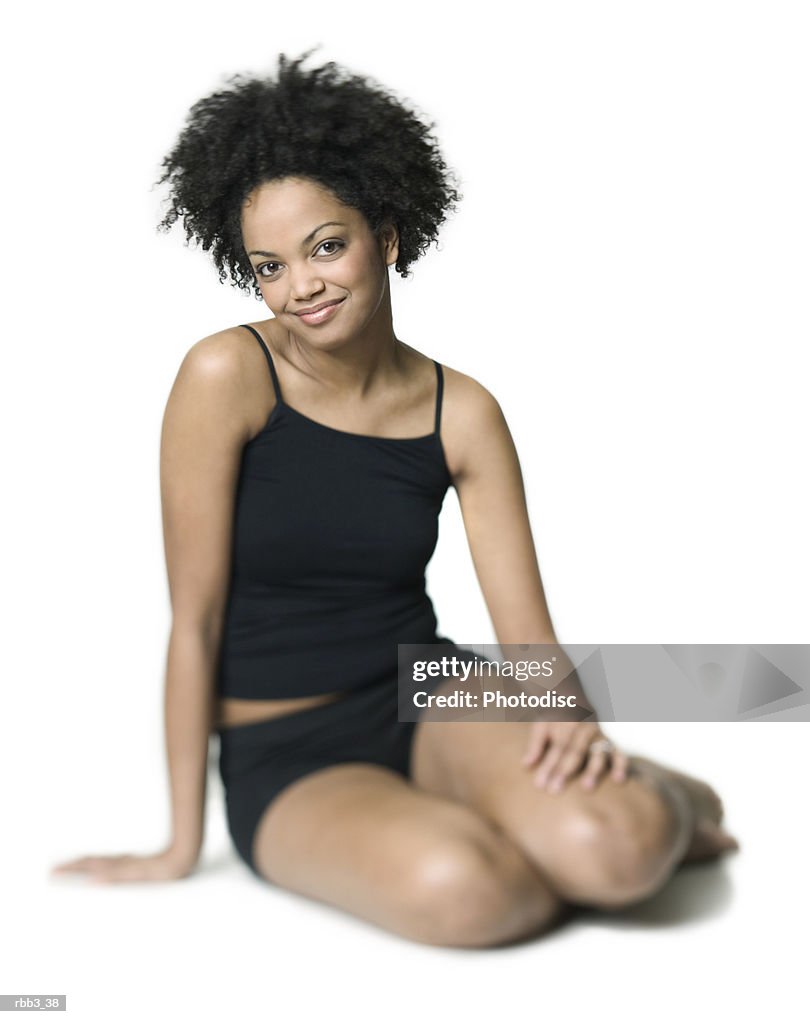 Full body shot of a young african american woman in a black workout outfit as she smiles