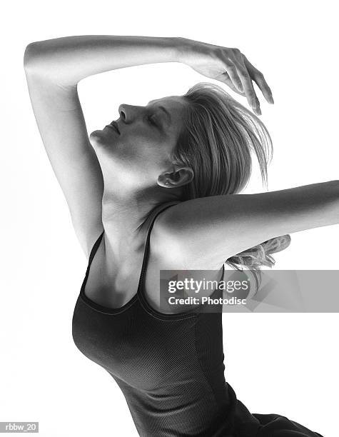 a caucasian woman stretches with her arm above her head - donna mezzo busto bianco e nero foto e immagini stock