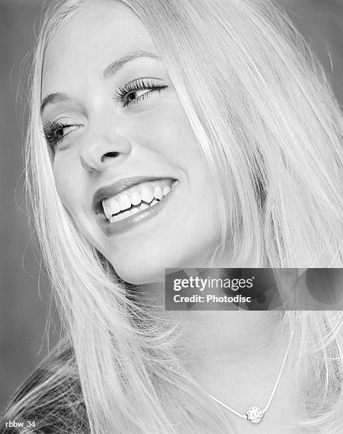 a happy blonde teenager smiles to the side - happy stockfoto's en -beelden