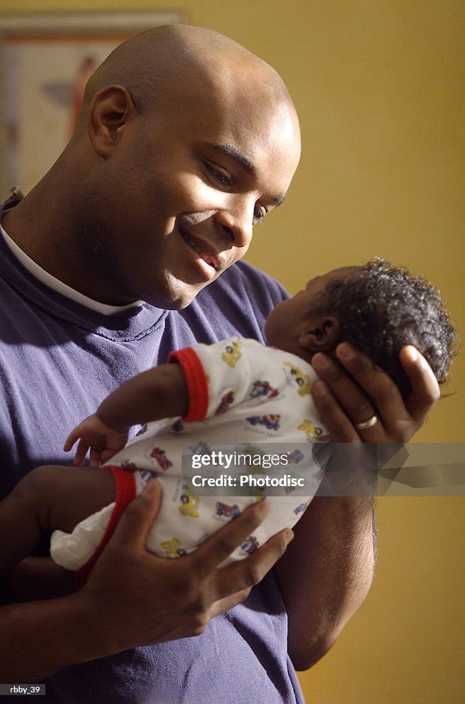 An african american father holds his son close as he looks at him lovingly