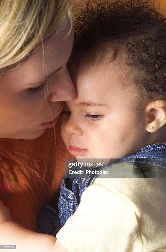 A young mother holds her african american daughter close to console her