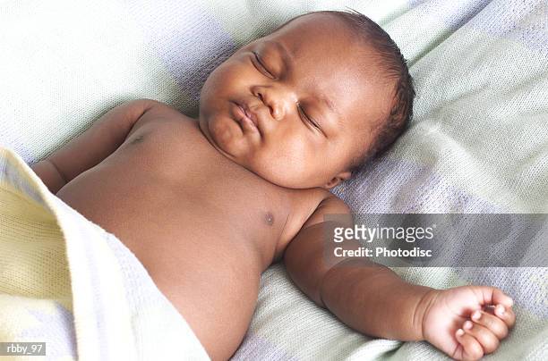 an african american baby lies on its back and sleeps peacefully - baby sleeping stock pictures, royalty-free photos & images