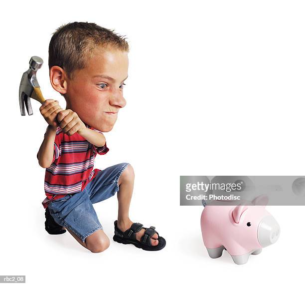 photo caricature of a little boy breaking his piggy bank with a hammer - klauwhamer stockfoto's en -beelden