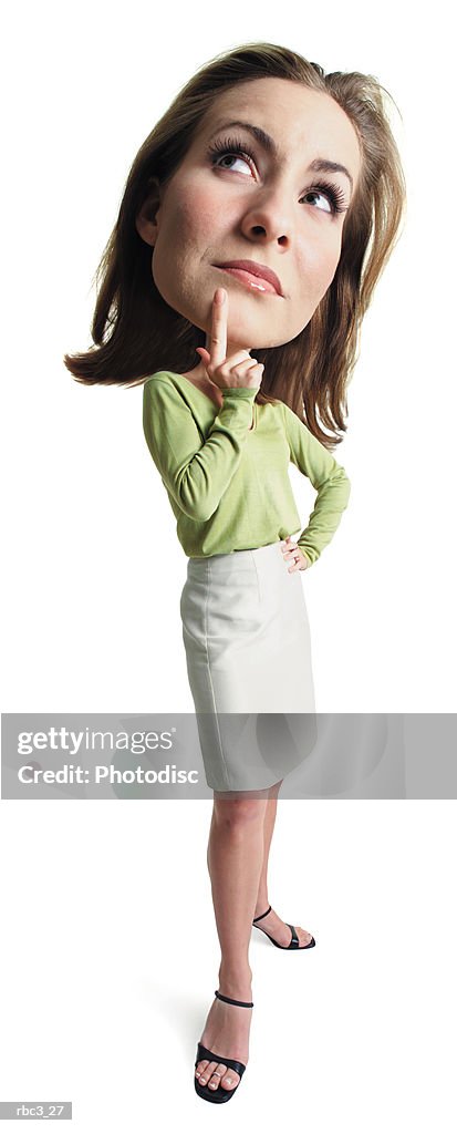 A young attractive caucasian female in a tan skirt and green blouse stands thinking with her finger to her chin