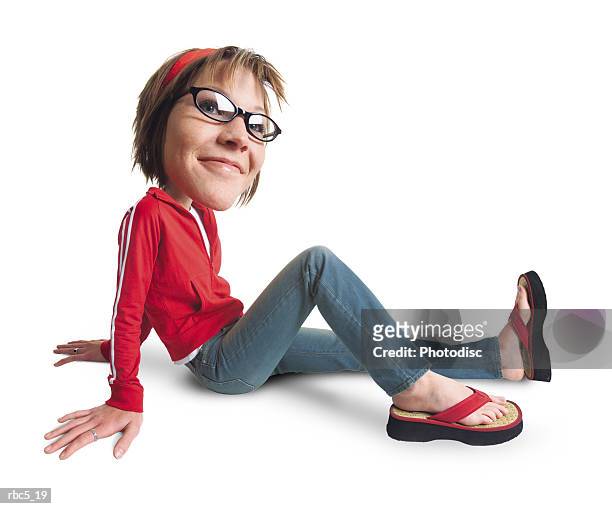 a young caucasian female wearing horn rimmed glasses and a red headband sits on the floor with her legs stretched out and leaning back on her hands - horn rimmed glasses - fotografias e filmes do acervo