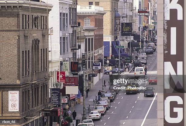 cars line the edge of and drive on a road between towering buildings. - awareness film festival opening night premiere of the road to yulin and beyond arrivals stockfoto's en -beelden