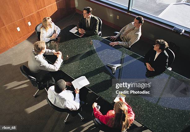 a business group gathers around a black marble table for a meeting - marble - fotografias e filmes do acervo