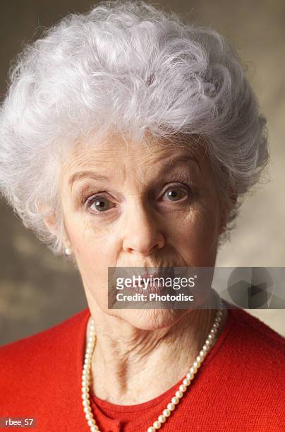 elderly woman with curly white hair wears red shirt raises eyebrows purses lips apprehensive look - curly stock pictures, royalty-free photos & images