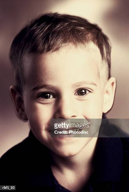 happy african-american boy with big brown eyes and very short black hair wearing a green shirt gives the camera a slight smile - big smile stockfoto's en -beelden