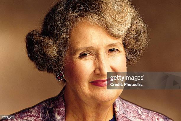 happy elderly woman female with short white gray hair wearing a floral shirt and pink lipstick smiles at the camera - happy stockfoto's en -beelden