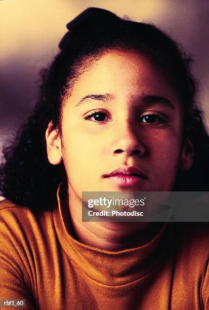 older hispanic girl with dark hair half pulled up wearing an orange turtleneck stares seriously off to her left - turtleneck stock pictures, royalty-free photos & images