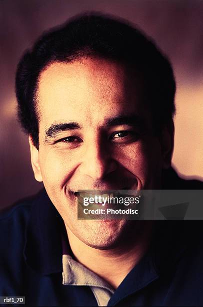 happy middle-aged man male with dark hair wearing a dark shirt smiles - happy stockfoto's en -beelden