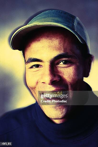 happy man wearing a dark shirt with a hat smiles and laughs - happy stockfoto's en -beelden