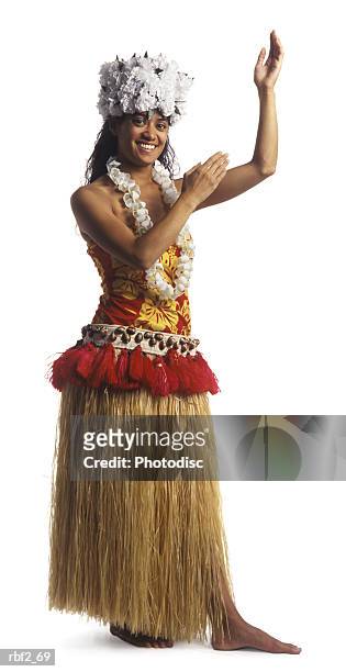 a young adult female in a traditional grass skirt and lei dances the hula and smiles - hawaiian lei stockfoto's en -beelden