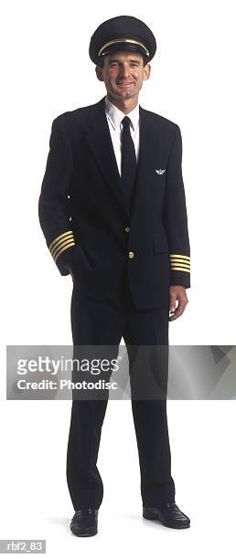 an adult male airline pilot in a blue uniform puts one hand in his pocket and smiles - berretto da uniforme foto e immagini stock