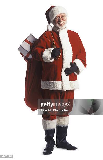 a man dressed as santa clause holds a bag over his shoulder and pats his stomach as he smiles - pats stock pictures, royalty-free photos & images