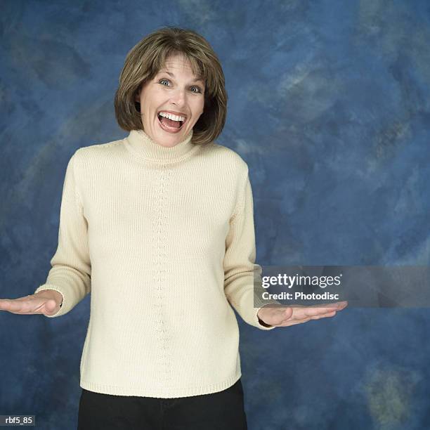 a portrait of a caucasian in a yellow turtleneck looking pleasantly surprised with her harnds out to the side and tilted upward - turtleneck stock pictures, royalty-free photos & images