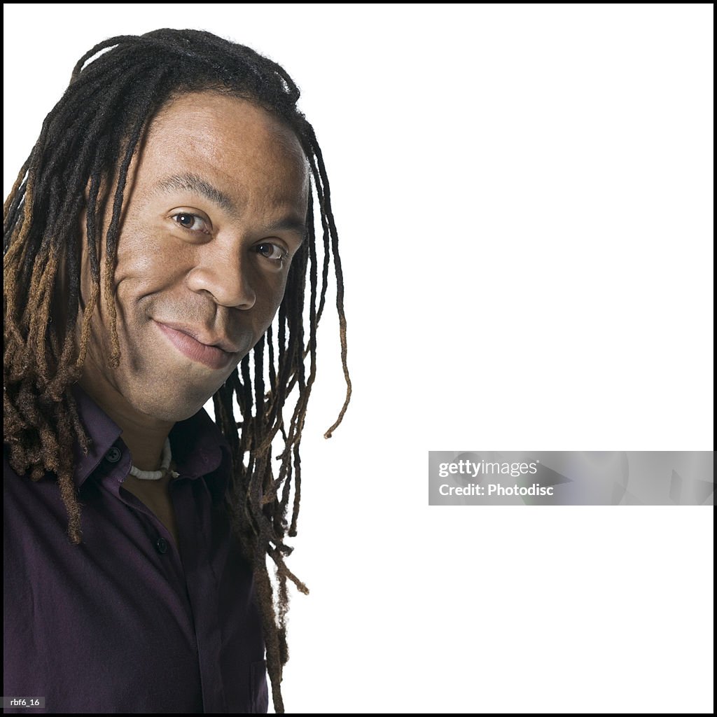 Portrait of a young adult male in a purple shirt as he turns and smiles slightly
