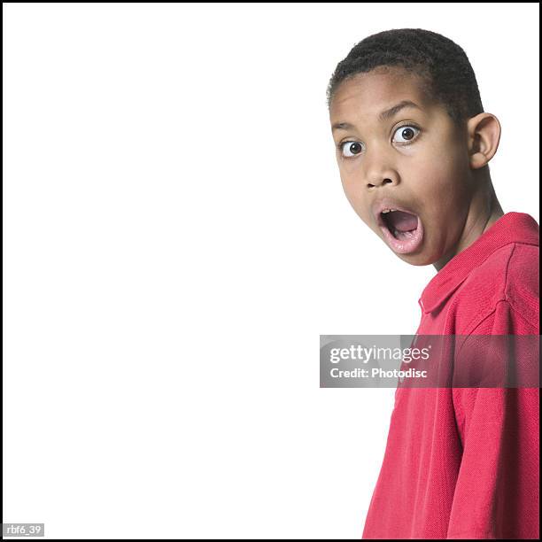 portrait of a male child in a red shirt as he turns and acts very surprised - african male red shirt stock-fotos und bilder