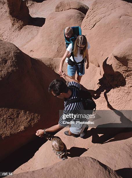 a young family hikes across red rocks - across stock pictures, royalty-free photos & images