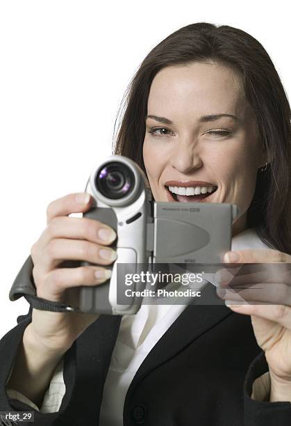 medium shot of a young adult woman as she playfully uses a video camera - uses stock pictures, royalty-free photos & images