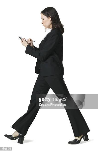 full body shot of a young adult business woman as she walks using her palm pilot - full body isolated bildbanksfoton och bilder