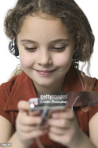 close up shot of a young female child as she listens to music on a mp3 player - electronic music 個照片及圖片檔