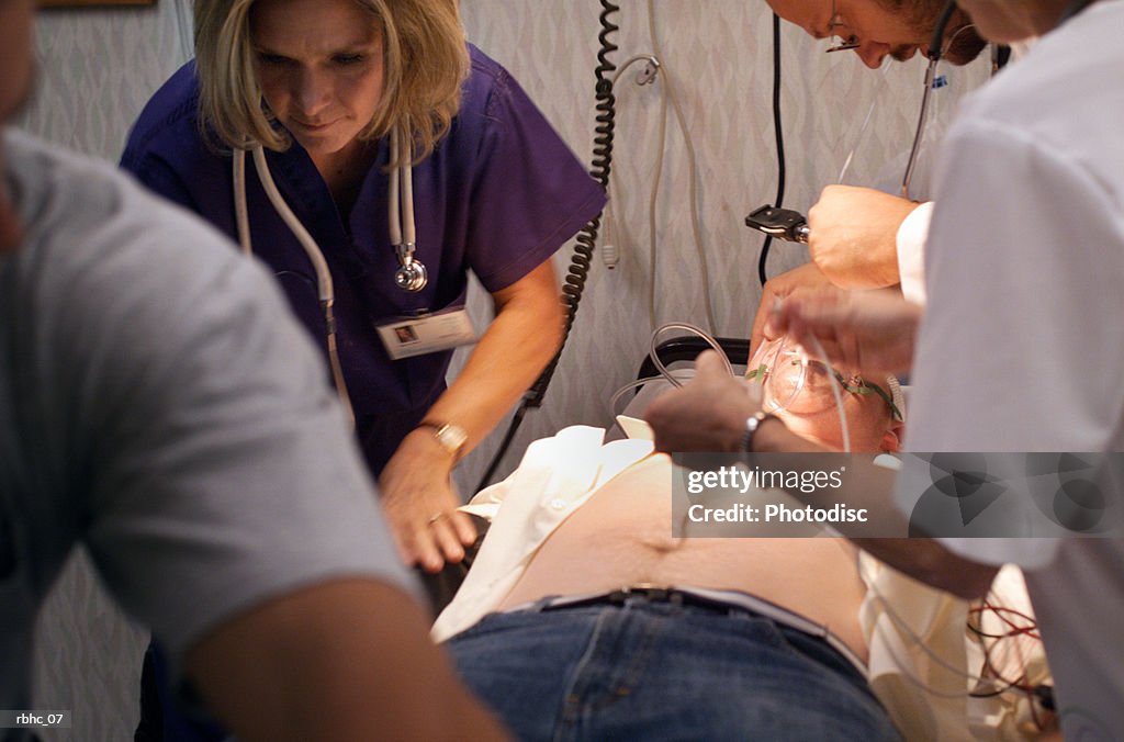 Caucasan nurses and an emt work over a male trauma victim