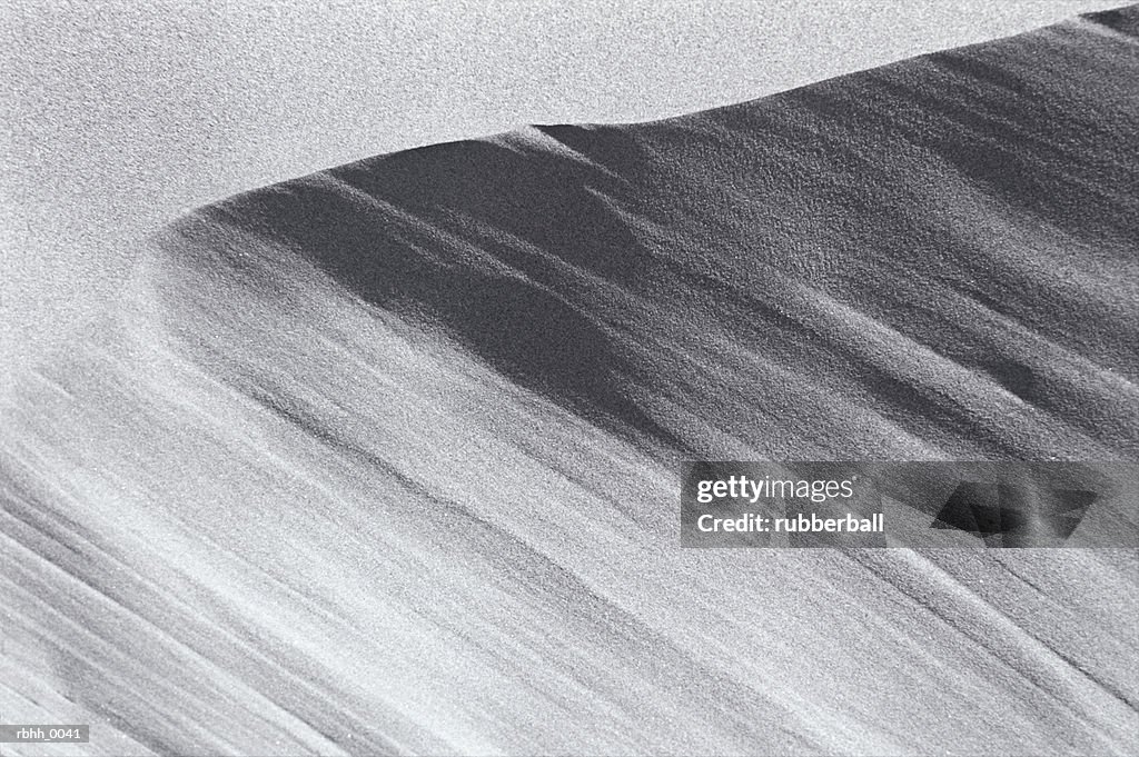 Black and white abstract photograph of a rolling sand dune