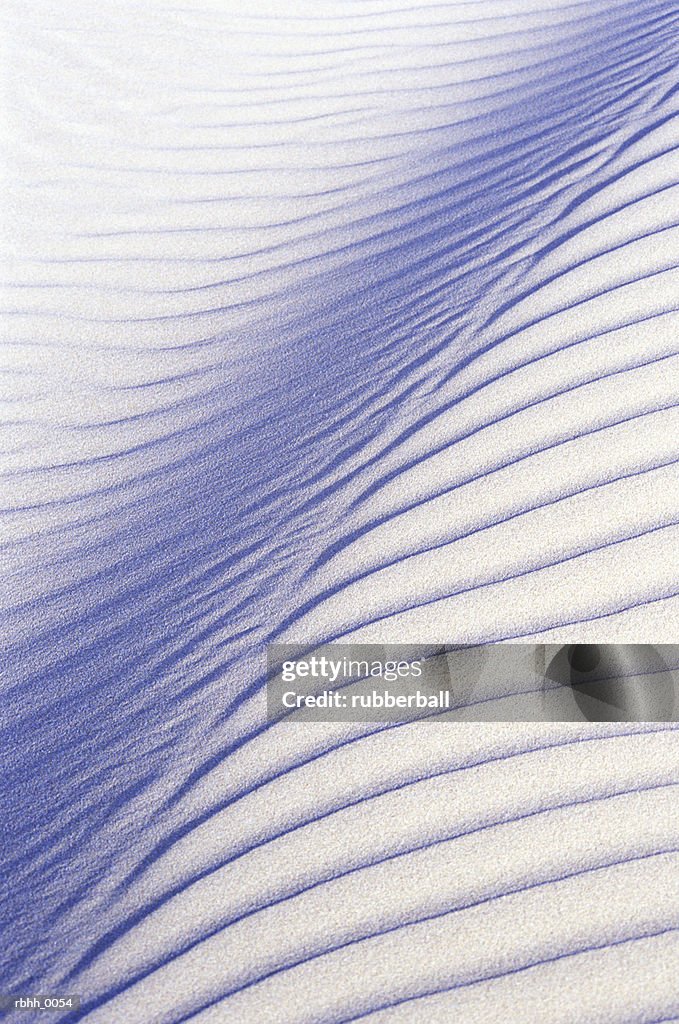 Abstract photograph of a pattern of lines seen covering a field of sand