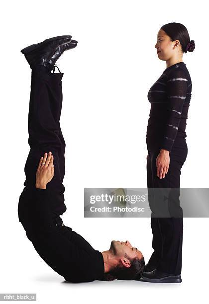 two young adults dressed in black create the letter u - u bend stock pictures, royalty-free photos & images