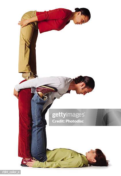 three young adults in colorful clothes create the letter e - dele e dela imagens e fotografias de stock