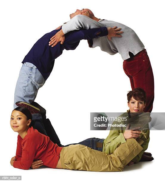 four young adults in colorful clothes create the letter o - o foto e immagini stock