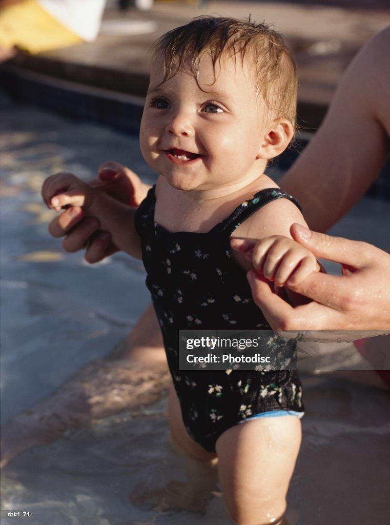 A caucasian baby wades in a kiddie pool