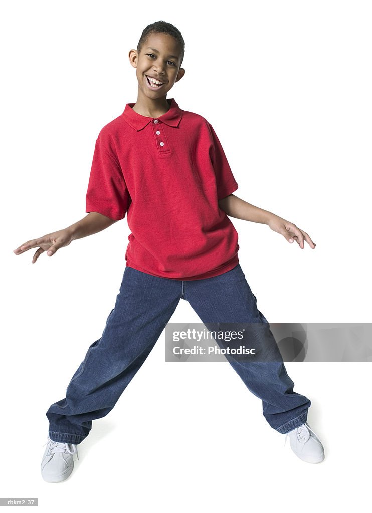 Full body shot of a male child as he spreads out his arms and dances