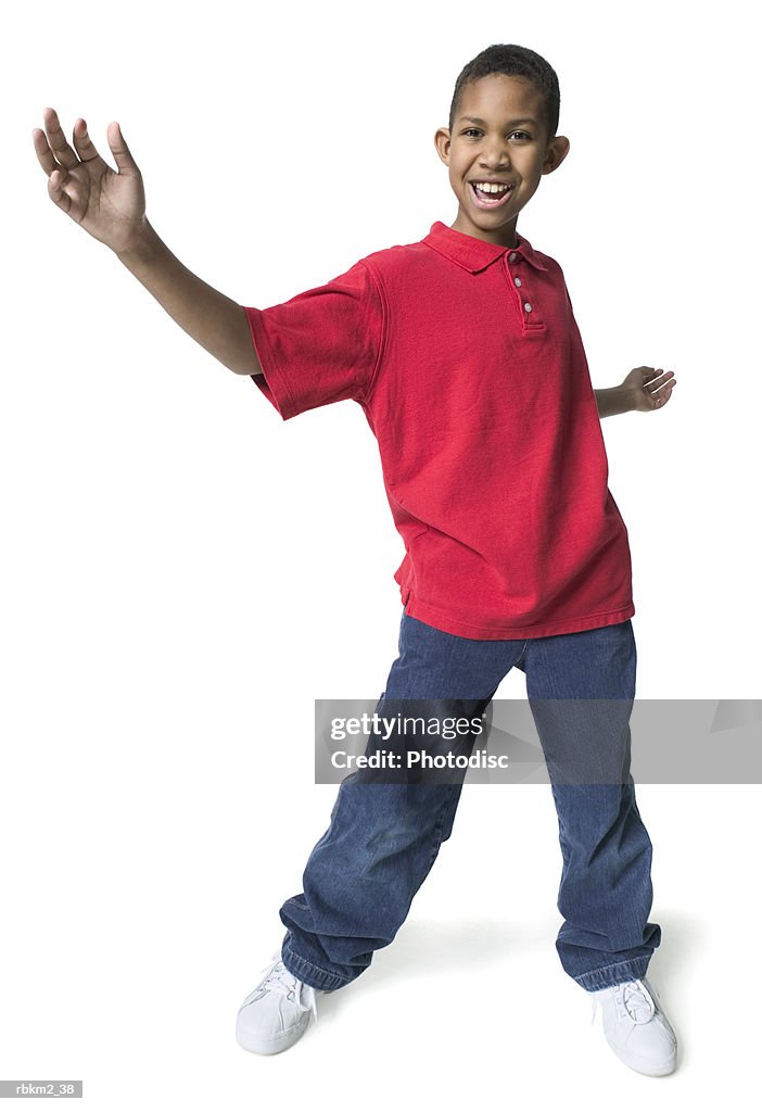 Full body shot of a male child as he dances and spreads out his arms