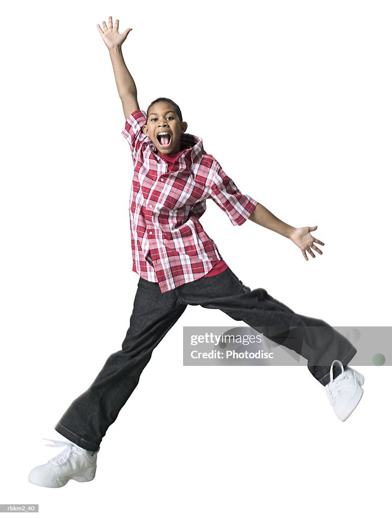 Full body shot of a male child as he jumps up playfully through the air