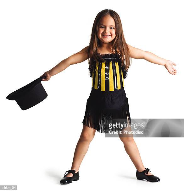a little ethnic girl in a dance outfit spreads her arms out and smiles while holding a top hat - tap dancing stock-fotos und bilder