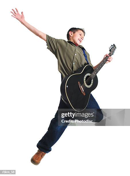 a young caucasian boy jumps into the air and throws his arm up while playing his guitar - modern rock stock pictures, royalty-free photos & images