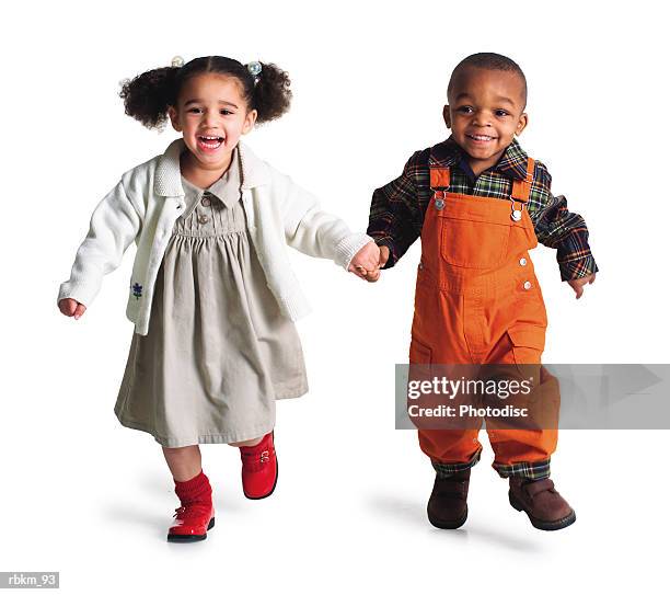 a cute little african american girl runs and laughs as she holds hands with her brother - two people white background stock pictures, royalty-free photos & images