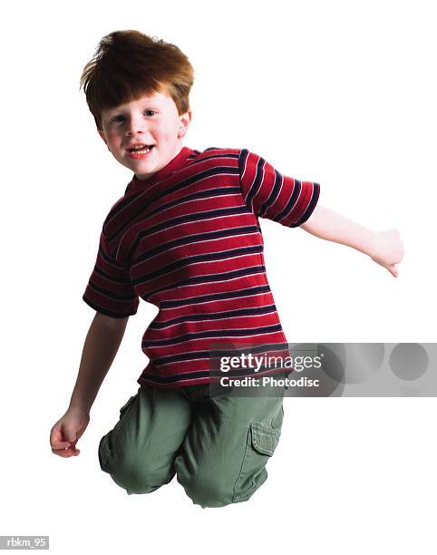 a cute littel redheaded boy jumps up high into the air and tuck his legs behind him - littel imagens e fotografias de stock