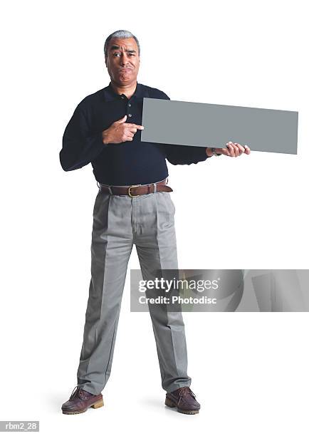 an elderly african american male in grey pants and a black shirt points to a  sign he is holding up - grey shirt stock pictures, royalty-free photos & images