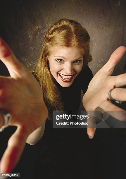 a happy red-haired woman reaches out towards the camera - woman reaching hands towards camera stock pictures, royalty-free photos & images