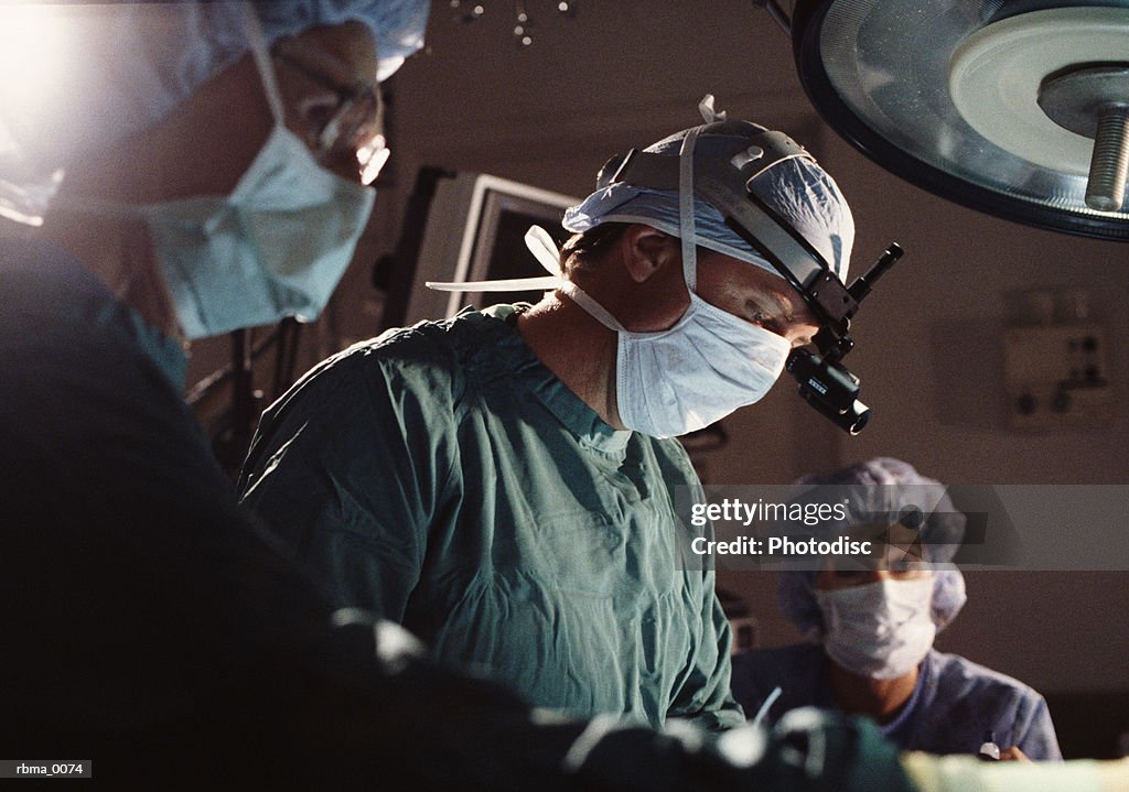 A group of doctors and nurses perform surgery in an operating room