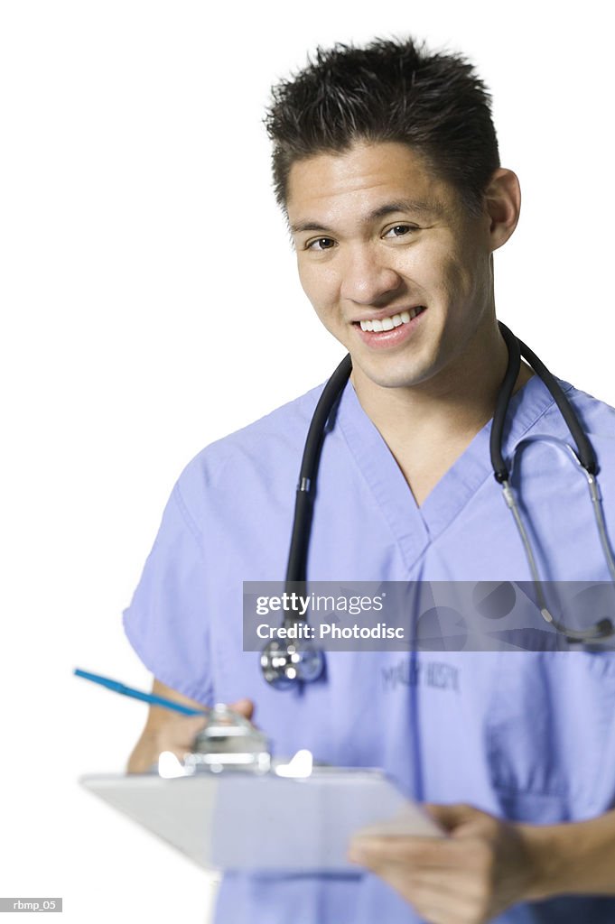 Portrait of a young adult male in blue scrubs as he holds a clipboard and smiles