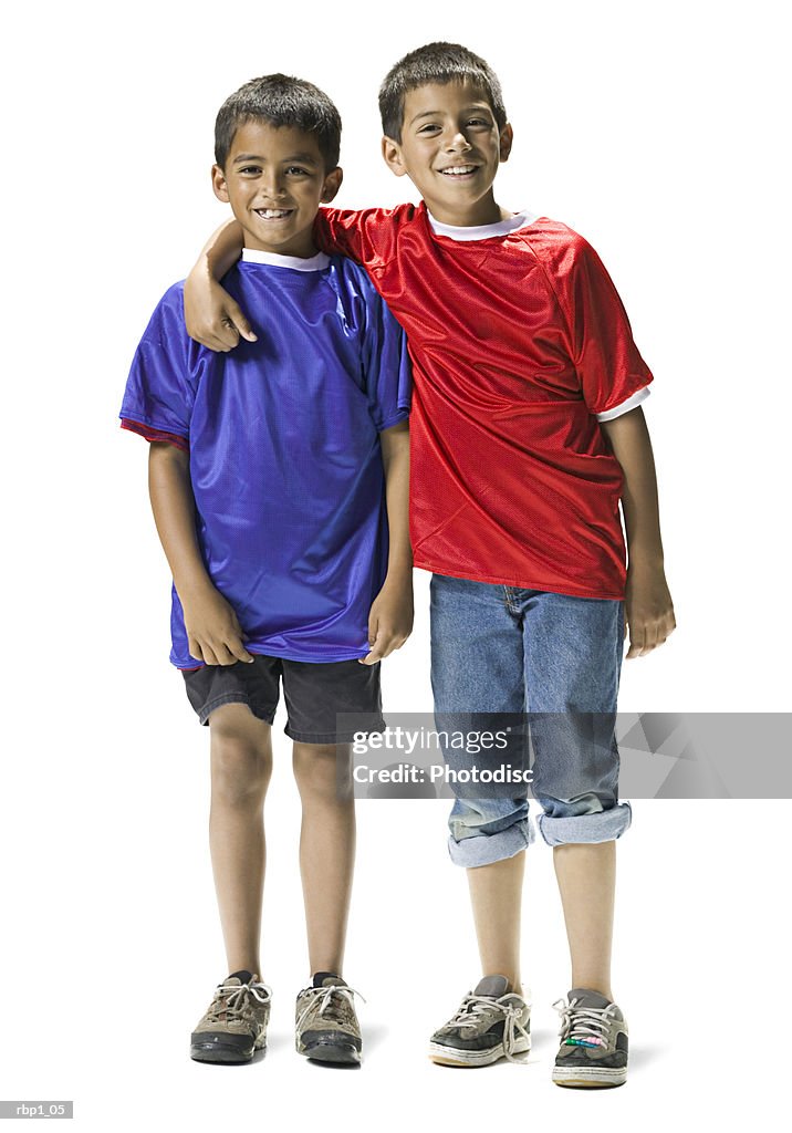 Full length shot of two young brothers in blue and red shirts as they smile at the camera