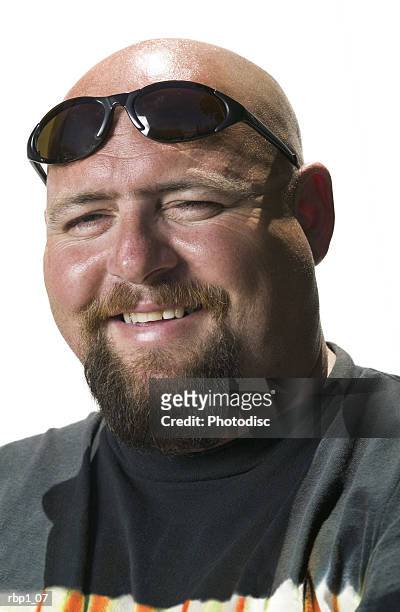 head and shoulders portrait of an adult male in a black shirt and sunglasses as he smiles - goatee stockfoto's en -beelden