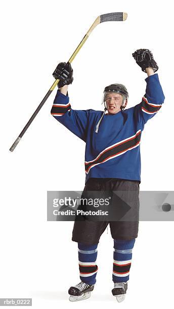 an adult caucasian male hockey player in a blue jersey raises his arms and stick to celebrate a goal - ijshockeytenue stockfoto's en -beelden