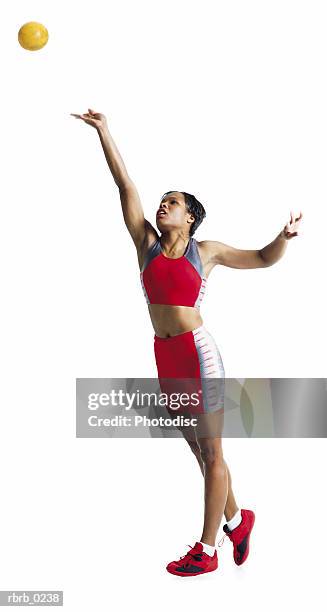 a young african american female athlete wearing red and gray winds up and throws a shot-put - womens field event stockfoto's en -beelden